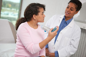 Young woman with doctor talking about asthma inhaler